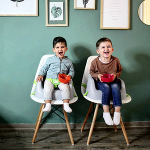 Zwei Kinder die auf Sitzerhöhungen von Koru Kids sitzen Toddler Booster